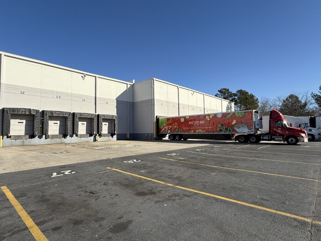 Exterior of food distribution building with What Chefs Want red truck
